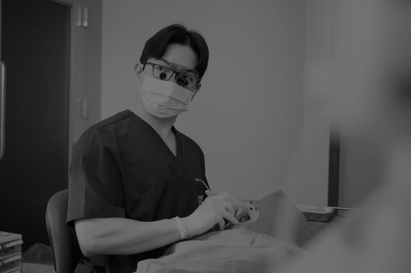 서울정석치과 원장이 확대경을 쓰고 임플란트 수술을 진행하는 모습